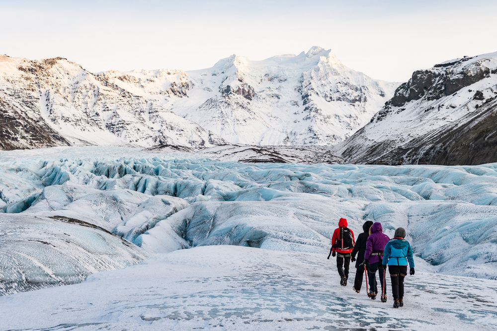 Hikers exploring a glacier landscape.