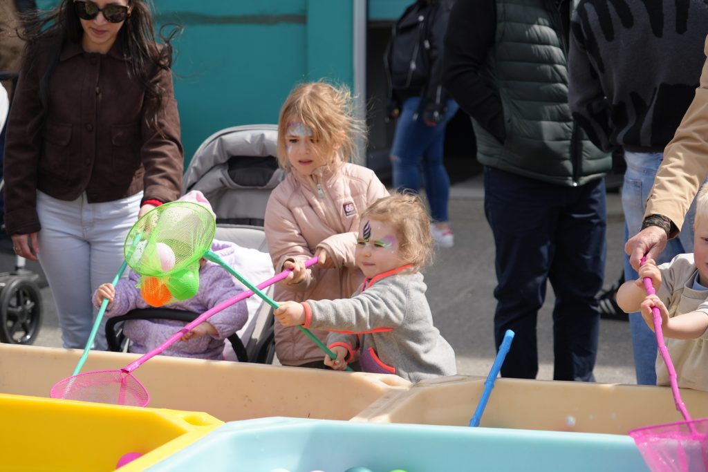 Two children with face paint play with a dip net.