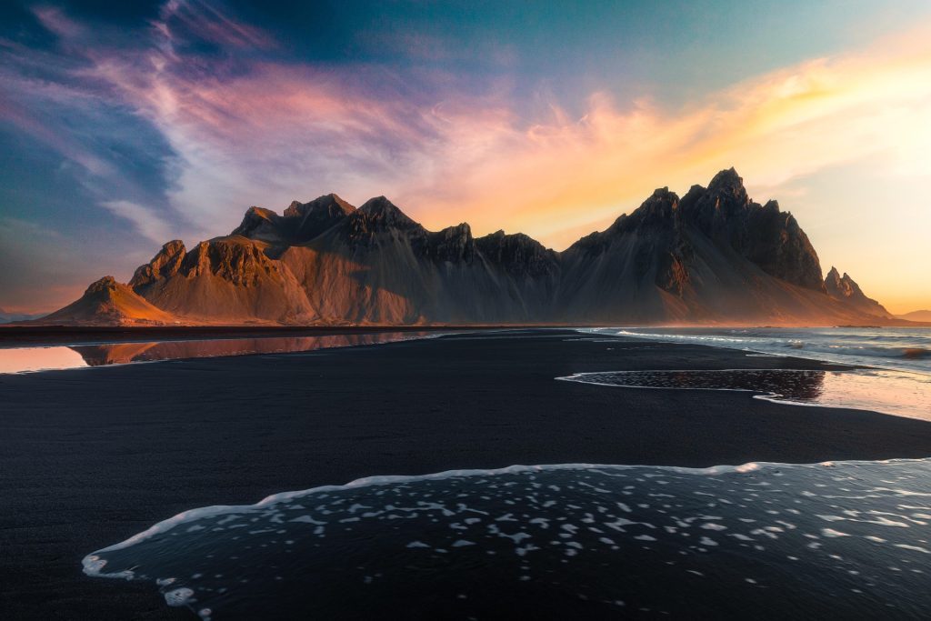 Midnight sun over Vestrahorn and the black sand beach in Iceland.