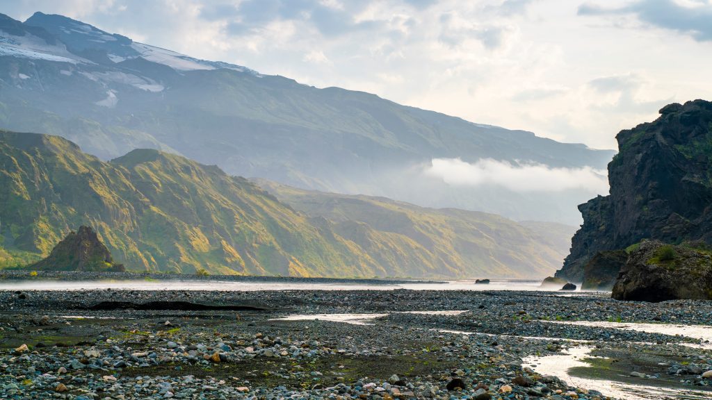 Wide view of a mountain valley with rocks and streams.