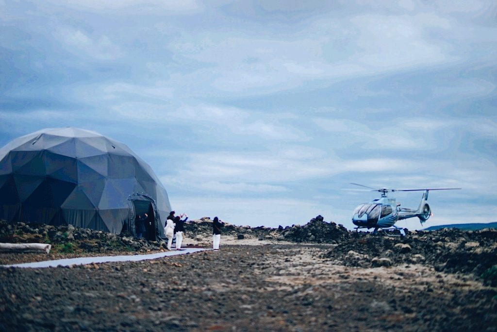 Destination management company in Iceland organizing an exclusive helicopter experience beside a geodesic dome.