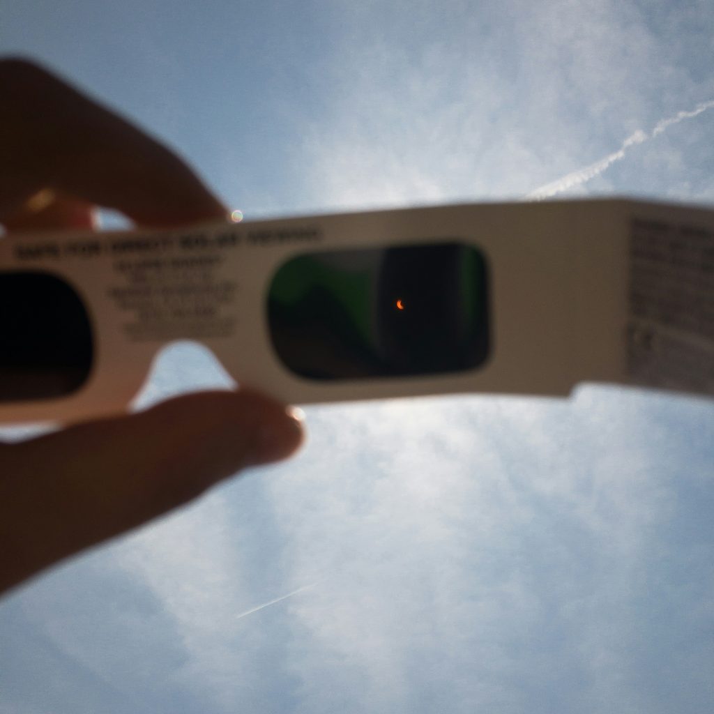 Partial solar eclipse viewed through protective eclipse glasses in Iceland.